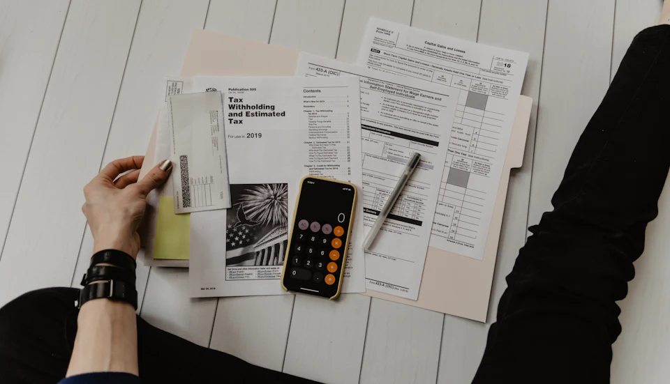 Accounting workspace with calculator, notebook, and financial documents